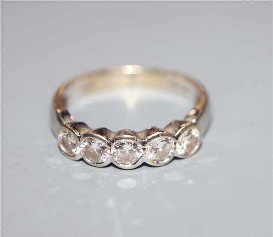A modern 18ct white gold and five stone diamond half hoop ring, size O.